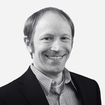 Smiling man in a suit and shirt.