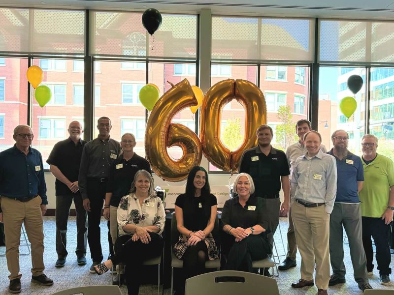 Group photo with "60" balloons and decorations.