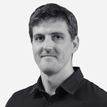 Man in black shirt, neutral expression.