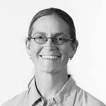 Smiling person with glasses, black and white.