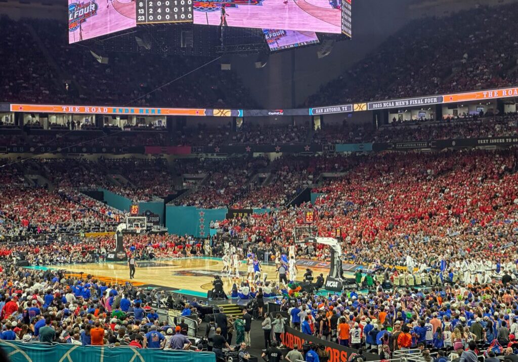 Basketball game in crowded indoor stadium.