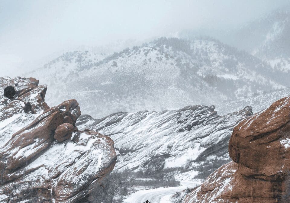 Snow-covered rocky landscape with a lone figure.