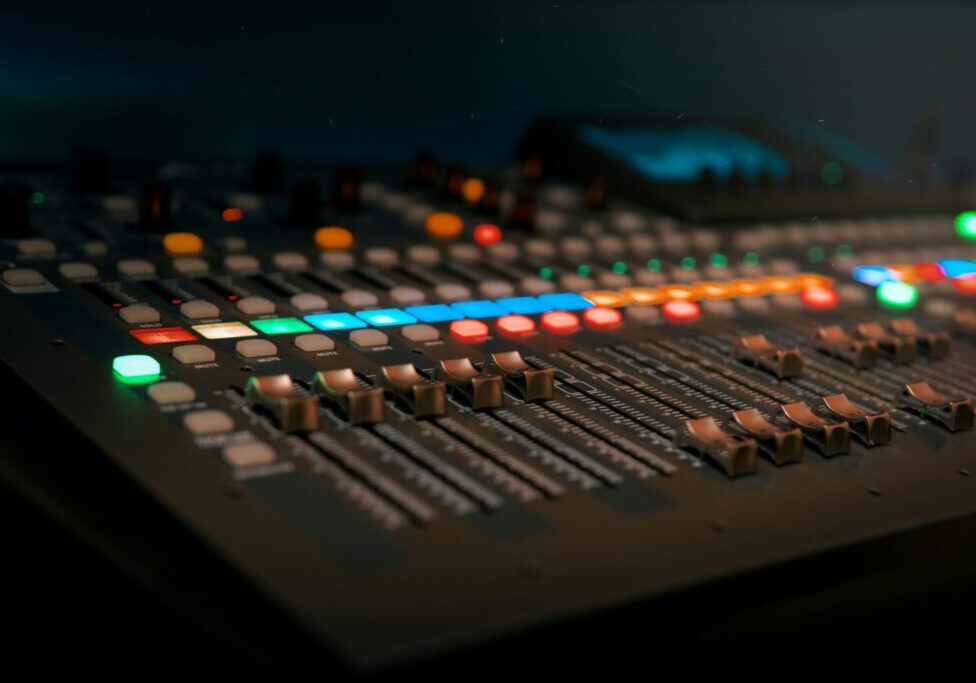 Audio mixing console with colorful lights.